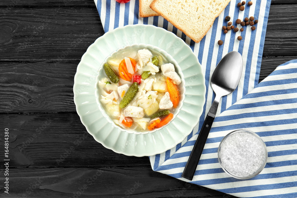 Plate with turkey soup on wooden table