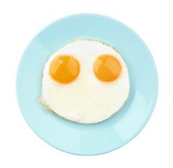 Plate with fried sunny side up eggs on white background