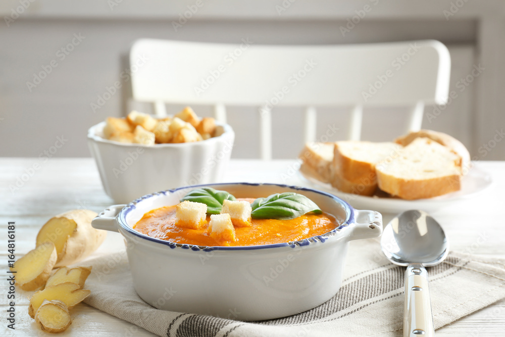 Delicious carrot soup on wooden table