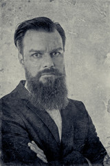 Wall Mural - Monochrome portrait of a young confident bearded man  with arms folded