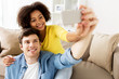 © Syda Productions - happy couple with smartphone taking selfie at home