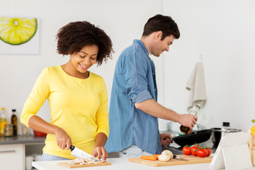 Wall Mural - happy couple cooking food at home kitchen