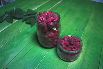 Fresh ripe raspberries on green wooden boards.