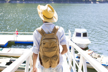 young traveller with the backpack at the jetty