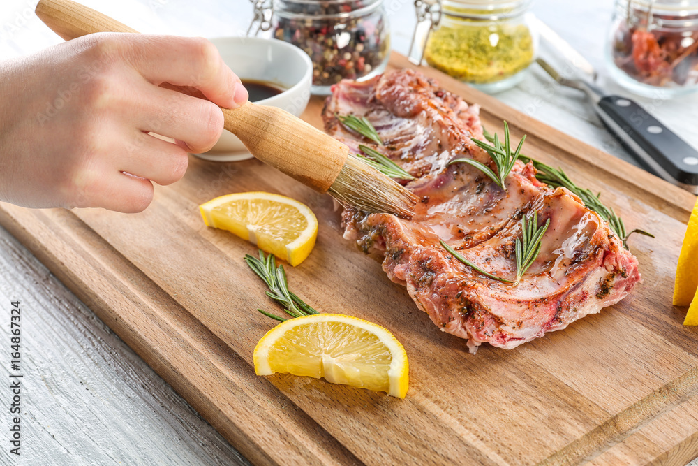 Woman preparing pork ribs, closeup