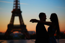 Silhouettes Of Romantic Couple Near The Eiffel Tower At Sunrise