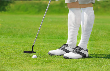 Wall Mural - Legs of young man playing golf on course in sunny day