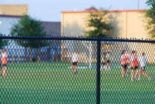 Football Field And Players Behind Chain Link Fence