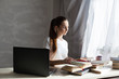 © dmitriisimakov - girl works at the computer reads books