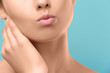 © Africa Studio - Closeup view of beautiful young woman with natural lips makeup touching neck on color background