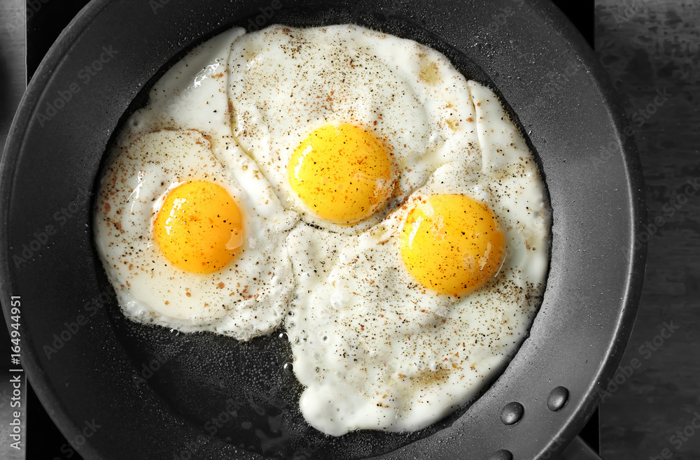 Delicious over easy eggs in pan, closeup