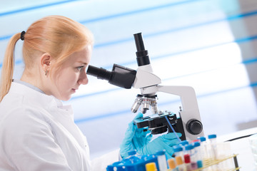 Poster - Doctor woman working  a microscope. Female scientist looking through a microscope in lab. Student girl looking in a microscope, science laboratory concept