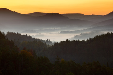 Wall Mural - Morning landspace with fog. Sunrise in landscape. Sun during sunrise in czech national park Ceske Svycarsko. Beautiful landscape with forest and fog. Sunrise with fog and sun. Misty morning landscape.