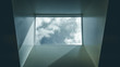 Modern interior skylight showing grey sky and misty clouds. Black and white skylight in modern office building. Abstract, artistic image of sky and clouds