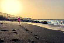Beautiful Woman Walks On The Beach Playa De Jardin, Tenerife, Canary Islands