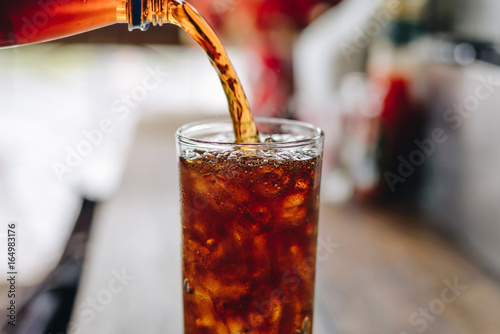 Fotomural Verter el agua de cola en el vaso.