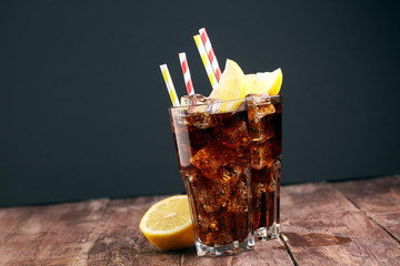 Wall Mural - Softdrink with ice cubes, lemon and straw in glass