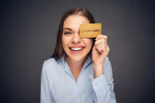 Woman Holding Credit Card Against Eye.