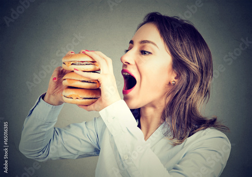 Cuadros en Lienzo Woman eating craving a double burger