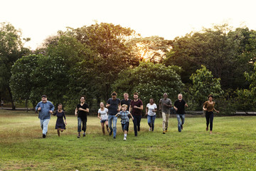 Wall Mural - Group of people walking and running playful in the park