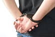 Close up of young prisoner get arrested by wearing handcuffs, isolated on white background