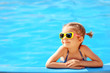 canvas print picture - Smiling cute little girl in sunglasses in pool in sunny day.