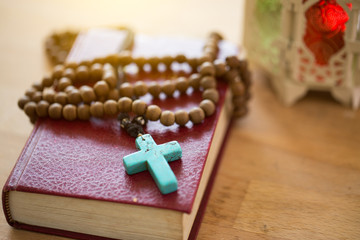 Wall Mural - Closeup of wooden Christian cross necklace next to holy Bible