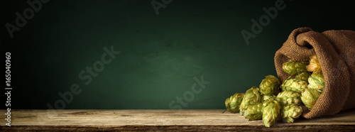 Fotografía blurred background of brown barrels and hop in basket