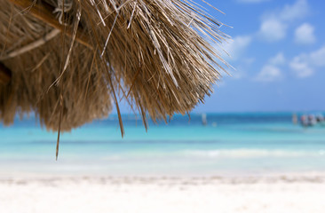 Wall Mural - Relaxing under the umbrella. Silent white sand beach on the shores of the Caribbean ocean. Sunny summer day. No people. Turquoise waters. Vacation concept image with copy space.