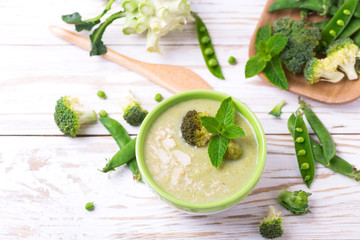 Wall Mural - Broccoli and green peas puree soup decorated with mint