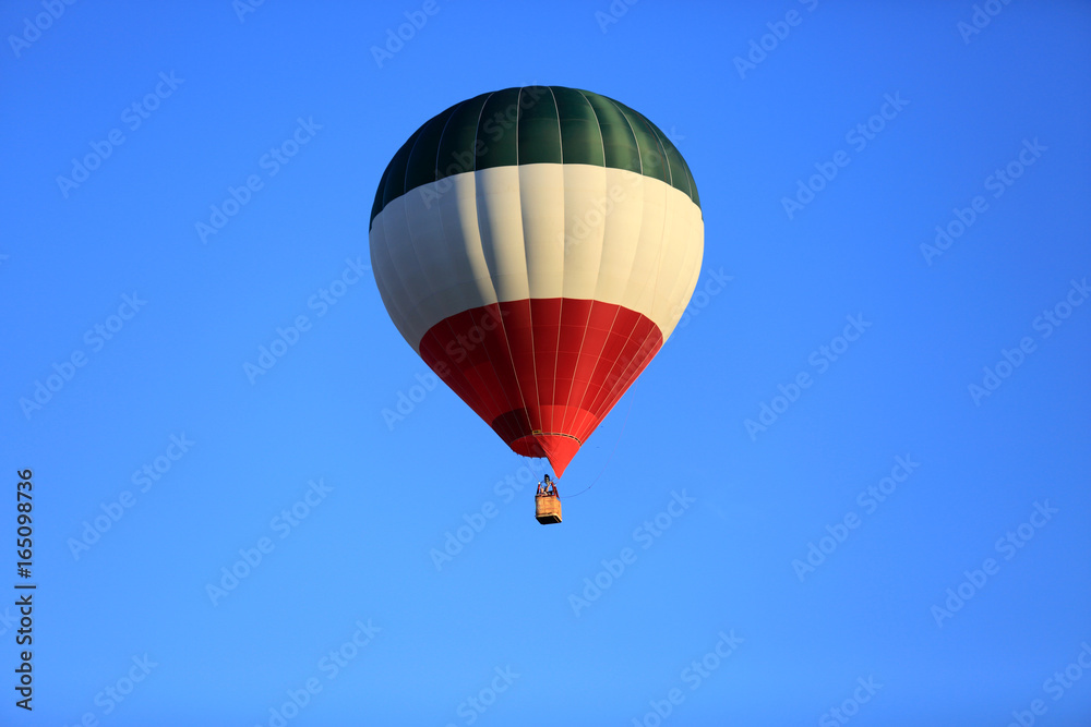 Kolorowy balon na gorące powietrze, na tle błękitnego nieba. - obrazy, fototapety, plakaty 
