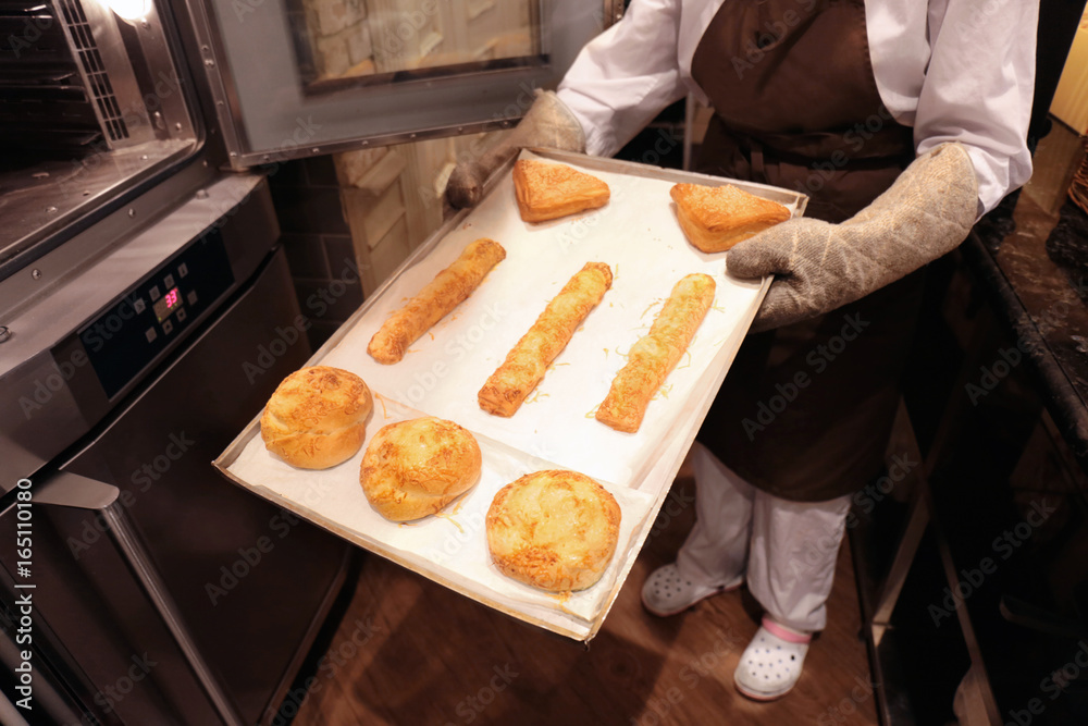 Woman holding tray with bakery products