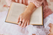 © Ellie Baygulov/Stocksy - Girl holding old book