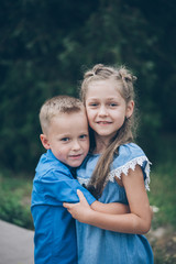 Two happy funny kids standing together hugging each other