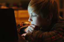 A Boy Reading By The Light Of An E-book