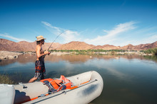 Man Taking Time To Catch Fish On The Orange River Whilst On A Rafting Trip