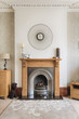© Ruth Black/Stocksy - Living room with fireplace, mirror and rug