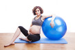 Young pregnant woman exercises with the ball