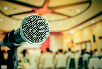 Close-up of microphone in conference seminar for speech with people meeting room in event blur light background