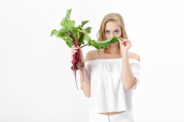 Sticker - Beautiful blond woman holds beetroot with green leaves on white background. Health and vitamins