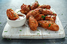 Baked Chicken Wings With Sesame Seeds And Sweet Chili Sauce On White Wooden Board.
