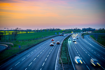 Colourful sunset at M1 motorway near Flitwick junction with blurry cars in United Kingdom