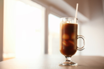 Sticker - Glass cup of cold brew coffee and straw on light blurred background