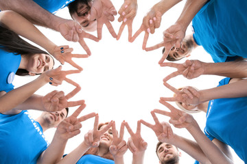 Canvas Print - Group of young volunteers making circle with their hands on white background