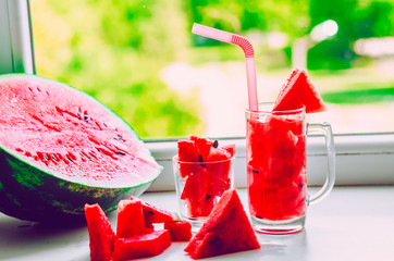 A glass with straws and watermelon juice.