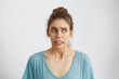 © WHstudio Leushin N - Beautiful woman in casual clothes looking nervously aside feeling distrust or fear while posing against white background. Scared blue-eyed female holding her breath with anticipation of horror