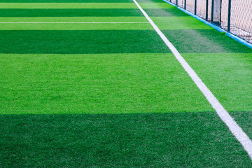 Wall Mural - Photo of a green synthetic grass sports field with white line shot from above