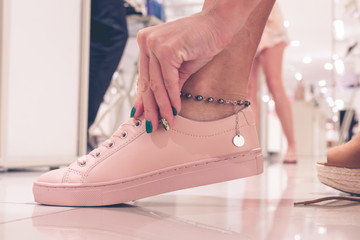  Young woman wearing new shoes in a shopping mall of Bali island, Indonesia.