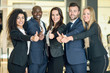 © javiindy - Group of businesspeople with thumbs up gesture in modern office.