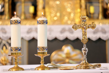 Golden cross on the altar with candles